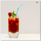 Bloody Mary Cocktail in glass with blue straw and cherry tomato and mint sprig garnish